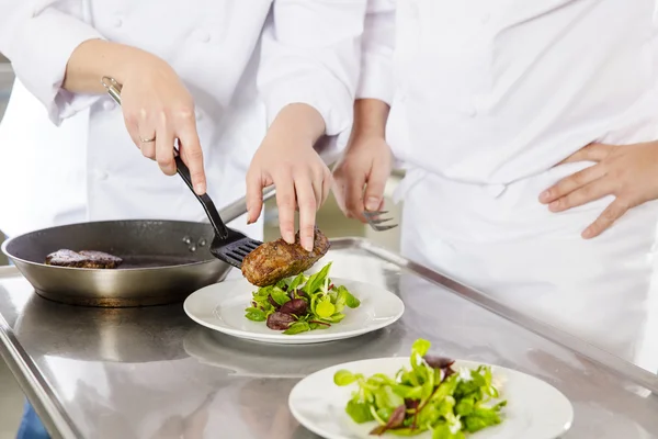Des chefs professionnels préparent des plats de steak au restaurant — Photo