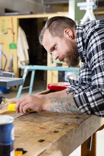 Artesano lijando un cuello de guitarra en madera en el taller — Foto de Stock