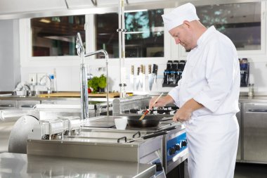 Şef mutfakta yemek hazırlamak için fırça kullanarak