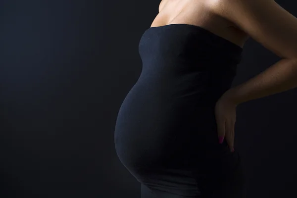 Belle femme enceinte avec les mains sur le dos — Photo