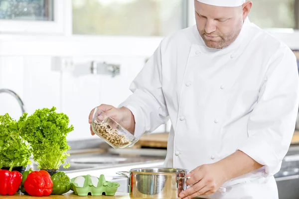 Chef professionnel préparant des aliments dans une grande cuisine — Photo