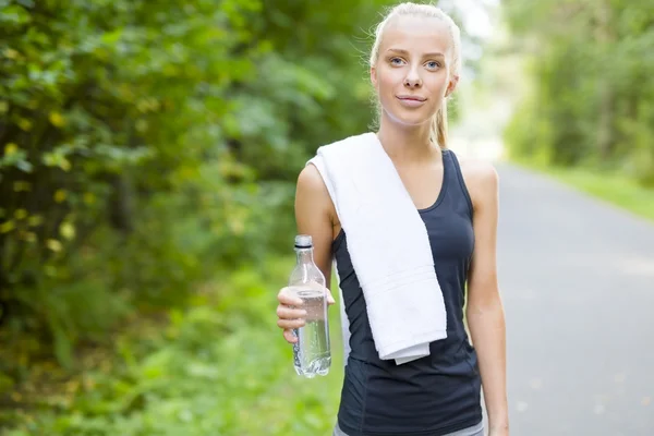 Leende ung kvinna med hennes genombrott efter löpning — Stockfoto
