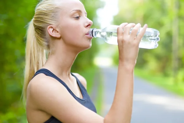 Woman runner drinking water after running Royalty Free Stock Photos