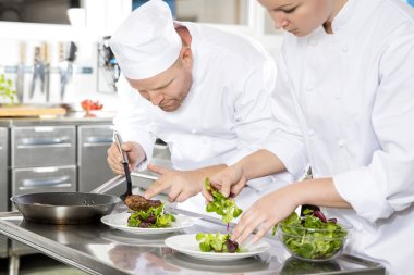 İki aşçılar gurme restoranda biftek yemek hazırlar