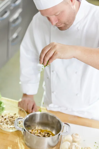 Chef profissional fazendo guarnição em grande cozinha — Fotografia de Stock