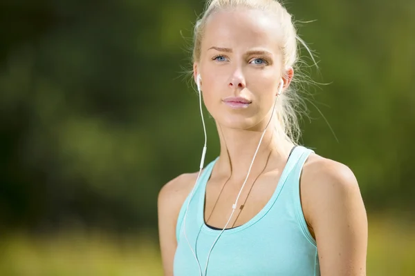 Mujer rubia escuchar música cuando hace ejercicio —  Fotos de Stock