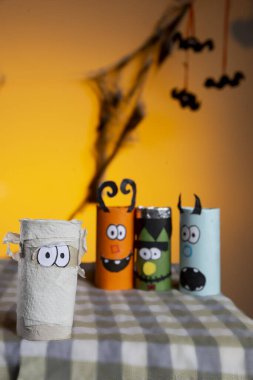 Turuncu gökyüzünün önünde üç yarasalı dört küçük canavar.