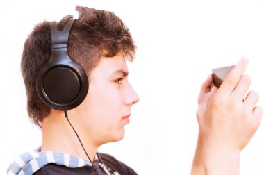 Adam kulaklıkla müzik dinliyor. Ellerinde tableti tutuyor ve müziği değiştiriyor. Bir profil portresi. İzole edilmiş