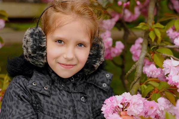 Портрет Милой Молодой Девушки Теплыми Наушниками Голове Розовых Цветах Весной — стоковое фото
