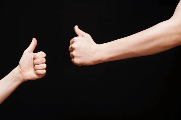 Dwie Ręce Naprzeciwko Siebie Czarnym Tle Pokazują Klasę Kciukiem Górze — Zdjęcie stockowe