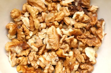 Tabakta soyulmuş ceviz var. Çok lezzetli. Kadın onları ev yapımı pişirmeye ekleyecek.