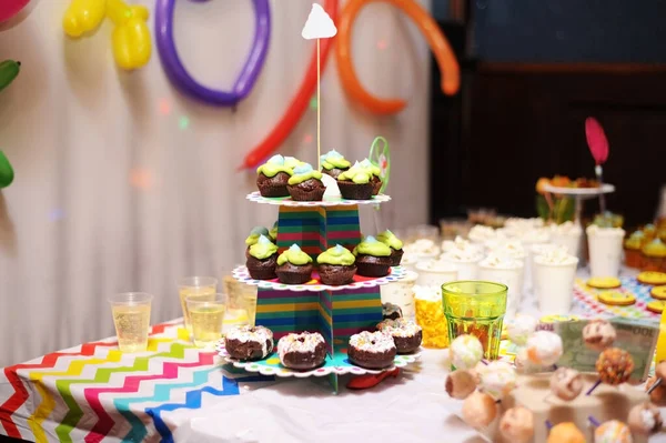 Different sweets, popcorn and sweet drinks on the table prepared for a fun party