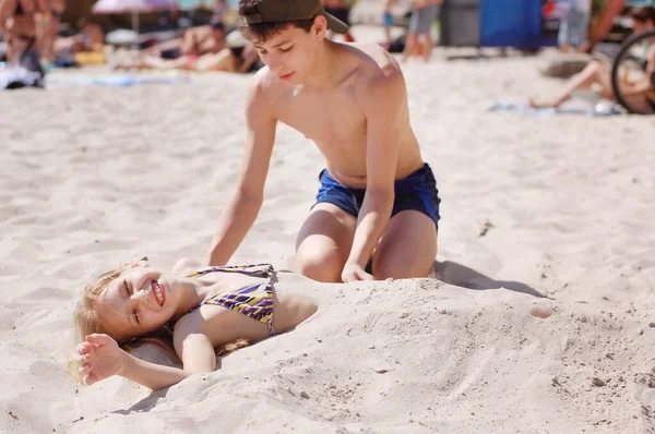 Мальчик Девочка Играют Пляже Мальчик Бросает Девочку Песок Девушка Счастлива Стоковое Изображение