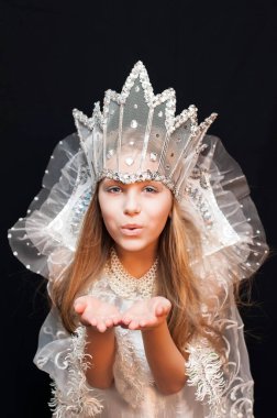 Kafasında taç olan Kar Kraliçesi kostümü giyen kız havada öpüşüyor. Dikey