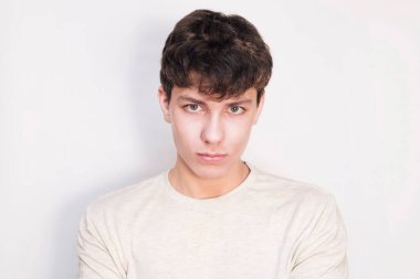 Beyaz gömlekli, arka planda yakışıklı bir genç. Çocuğun koyu renk saçları ve ciddi bir yüzü var. Sapı kopyala