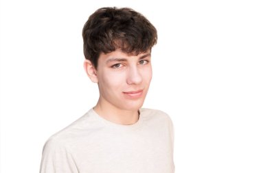 Beyaz bir arka planda yakışıklı bir gencin portresi. Adam yan yan duruyor ve gülümsüyor. İzole edilmiş