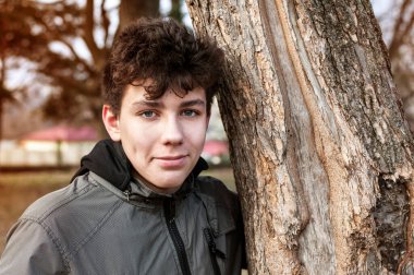 Sonbaharda sokakta antrenman yaptıktan ve koştuktan sonra dinlenen genç çocuk gülümsemek istiyor ama gülümsemiyor çünkü diş telleri onu engelliyor. Diş Konsepti