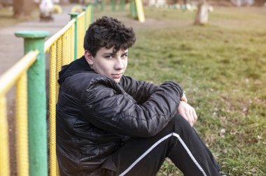 Genç bir delikanlı çimlerin üzerinde oturuyor ve gülümsüyor, sonbaharın başlamasına seviniyor, artık sıcak değil ve açık hava sporları yapabiliyor. Adam iyi bir ruh hali olsun diye ailesiyle barıştı.