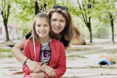 Ergenlik çağında güzel bir kız, annesi parkta dinleniyor. Uzun ve ciddi bir konuşmadan sonra gülümsüyorlar ve mutlular. Bir kadın kızına sarılıyor.