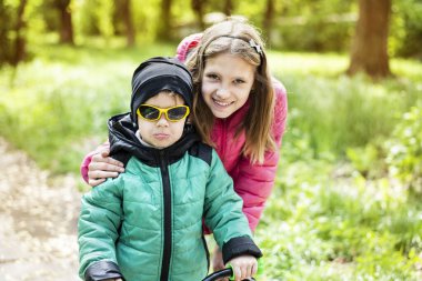 Genç bir çocuk ilkbaharda bisiklet sürmeyi öğrenir ve ablası ona bakar ve ona yardım eder. Ebeveynler çok çalışıyor, bu yüzden kız sık sık erkek kardeşine bakıyormuş gibi bakıyor.