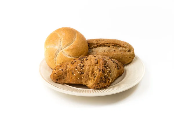 Three rolls of bread on an off-white plate — Stock Photo, Image