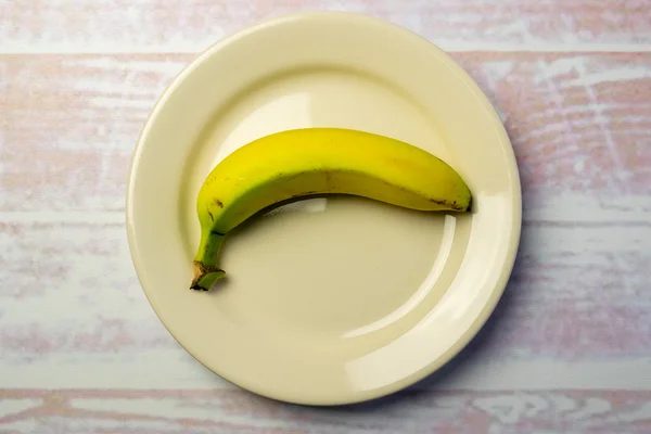 White round plate with a banana — Stock Photo, Image