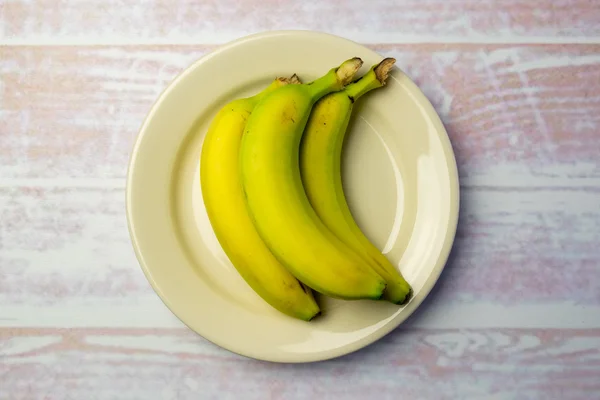 White round plate with three bananas — Stock Photo, Image