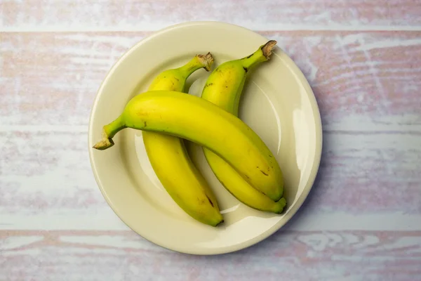 White round plate with three bananas — Stock Photo, Image