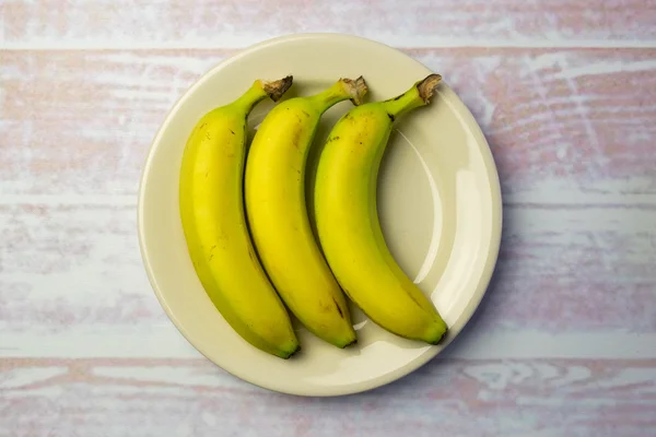 White round plate with three bananas — Stock Photo, Image