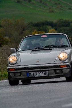 CAGLI, ITALY - OTT 24 - 2020: Porsche carrera 911 Mille Miglia 2020 rallisinde eski bir yarış arabasında ünlü İtalyan tarihi yarışı (1927-1957))