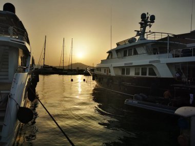 Olbia, Sardinya / İtalya - 2019 / 8 / 21: Günbatımında marina di Olbia limanı ve yat marinasının panoramik manzarası