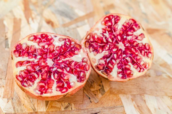 Nar, organik arka planda yarı yarıya açık. Sonbahar ya da kış mevsimsel meyveleri. C vitamini bakımından zengin sağlıklı süper yiyecekler..