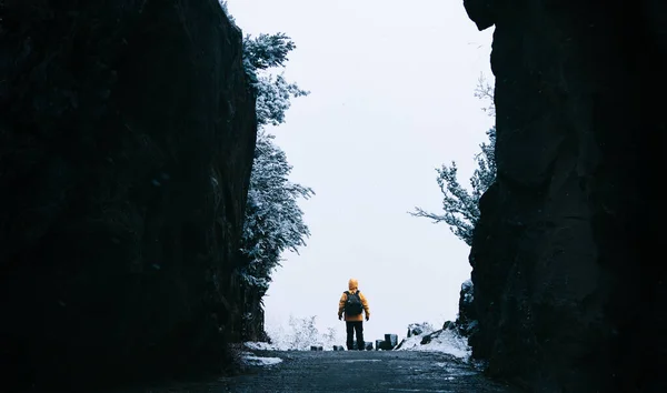 洞窟の中に黄色のジャケットの匿名の人 雪と冬の風景の中に旅行者 クリスマスと冬の休暇の概念 バックパッカー — ストック写真