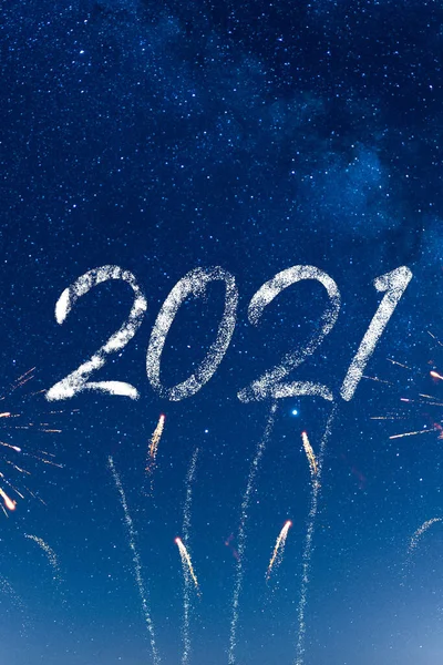 Mutlu yıllar 2021, noel kutlaması. Geceleri arka planda güzel, masmavi bir gökyüzünde havai fişekler. Yıldızlar ve Samanyolu. Amaçlar, hayaller, sihir ve dilek kavramı. Yeni Yıl Çanları.