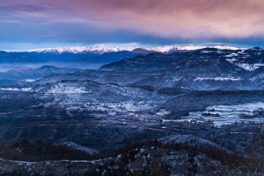 Soğuk bir gündoğumunda, karlı kış dağları manzarası. Buz tutmuş buzlu bir manzara. Bellmunt, Osona, Katalonya, İspanya ve Pireneler sıradağları.