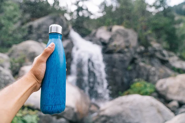 Sürdürülebilir ve yeniden kullanılabilir su şişesi. Mavi bir Çevre dostu su şişesi tutuyor. Tek kullanımlık plastik şişelere elveda. Plastiksiz ve sıfır atık. Sürdürülebilir hayat.