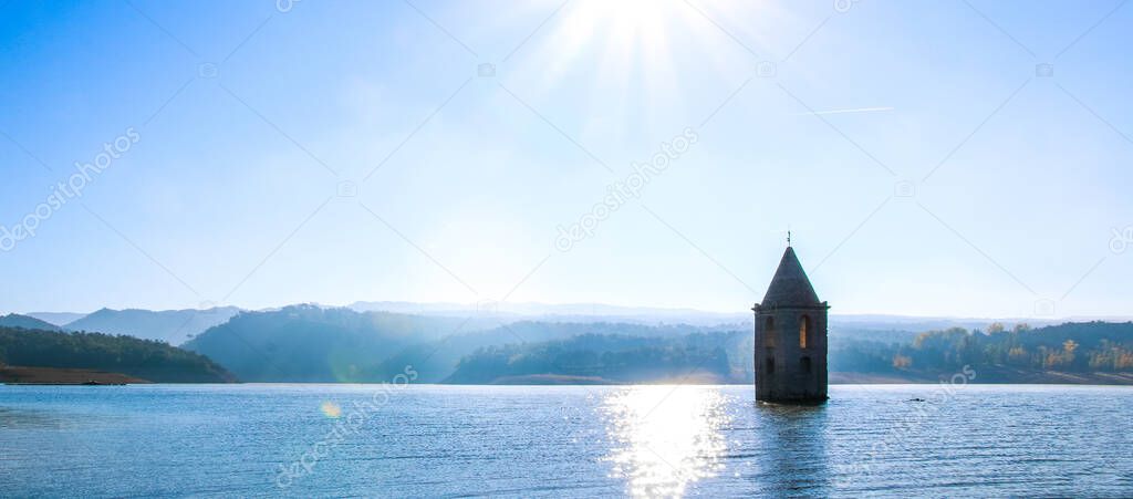Historic church of the Sau swamp. Panoramic view of Sau Reservoir. Landscape of the Sau swamp in a sunny day. Tourism in Osona, Barcelona, Catalunya, Spain.