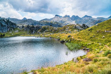 Dağlarla çevrili dağ gölü. Dağ gezisi ve yaz tatili kavramı. Circo Saboredo, Aran Vadisi Pireneleri, Katalonya, İspanya.