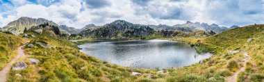 Dağlarla çevrili dağ gölünün panoramik manzarası. Dağ gezisi ve yaz tatili kavramı. Circo Saboredo, Aran Vadisi Pireneleri, Katalonya, İspanya.
