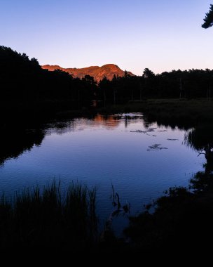 Pireneler, Katalonya, İspanya 'da bir alp gölünde güzel bir gün doğumu ya da gün batımı. Tatil kavramı, yaz tatili, rahatlama ve kopukluk. Vahşi doğa.