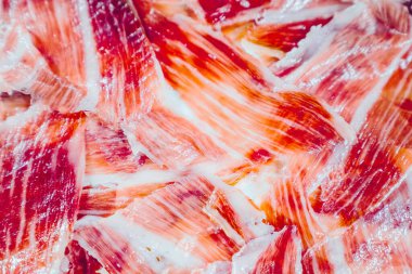 İberya jambonu ön planda iştah açıcı. İberya jambonu, Meşe palamudu ile beslenmiş Iberico jambonu. Pata negra, dilimlenmiş jambonun muhteşem görüntüsü. Tipik İspanyol yemeği ya da katalan yemeği. Kapat ve üst görünüm.