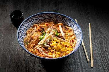 Japon miso ramen çorbası koyu arka planda yukarıdan izleniyor. Japon eriştesi.