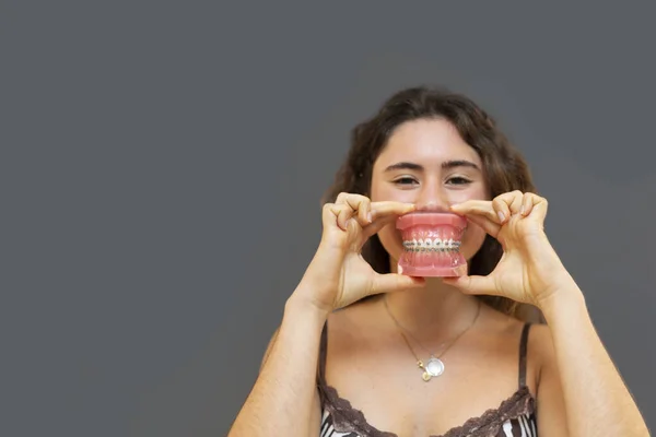 Retrato Niña Sonriente Sosteniendo Una Dentadura Postiza Con Fondo Gris — Foto de Stock