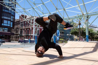 Sokakta akrobatik dansçı genç Latin bir adam gösteri yapıyor..
