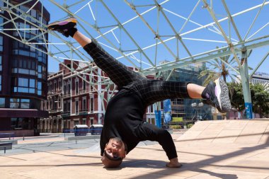 Sokakta akrobatik dansçı genç Latin bir adam gösteri yapıyor..