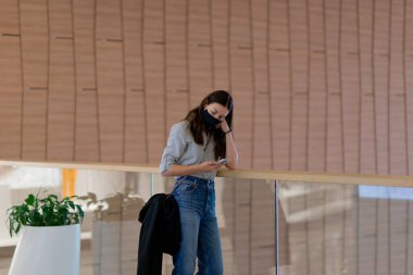 Yüzünde tıbbi maske olan genç bir kadın. Koronavirüs salgını sırasında solunum koruması..