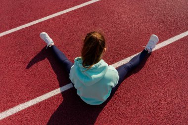 Sokakta antrenman yapan genç bir bayan sporcu sokak platformunda antrenman yapıyor..