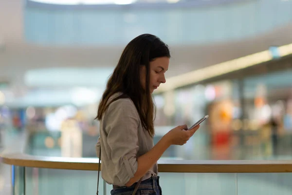 Fiatal nő a bevásárlóközpontban használ egy e-pénztárca vásárlás. — Stock Fotó