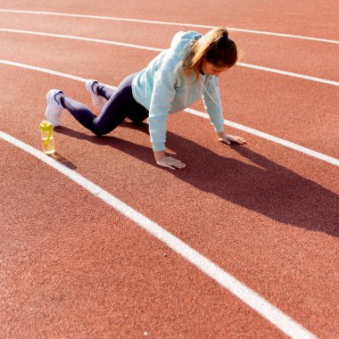 Sokakta antrenman yapan genç bir bayan sporcu sokak platformunda antrenman yapıyor..