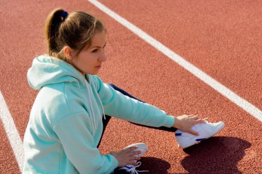 Sokakta antrenman yapan genç bir bayan sporcu sokak platformunda antrenman yapıyor..